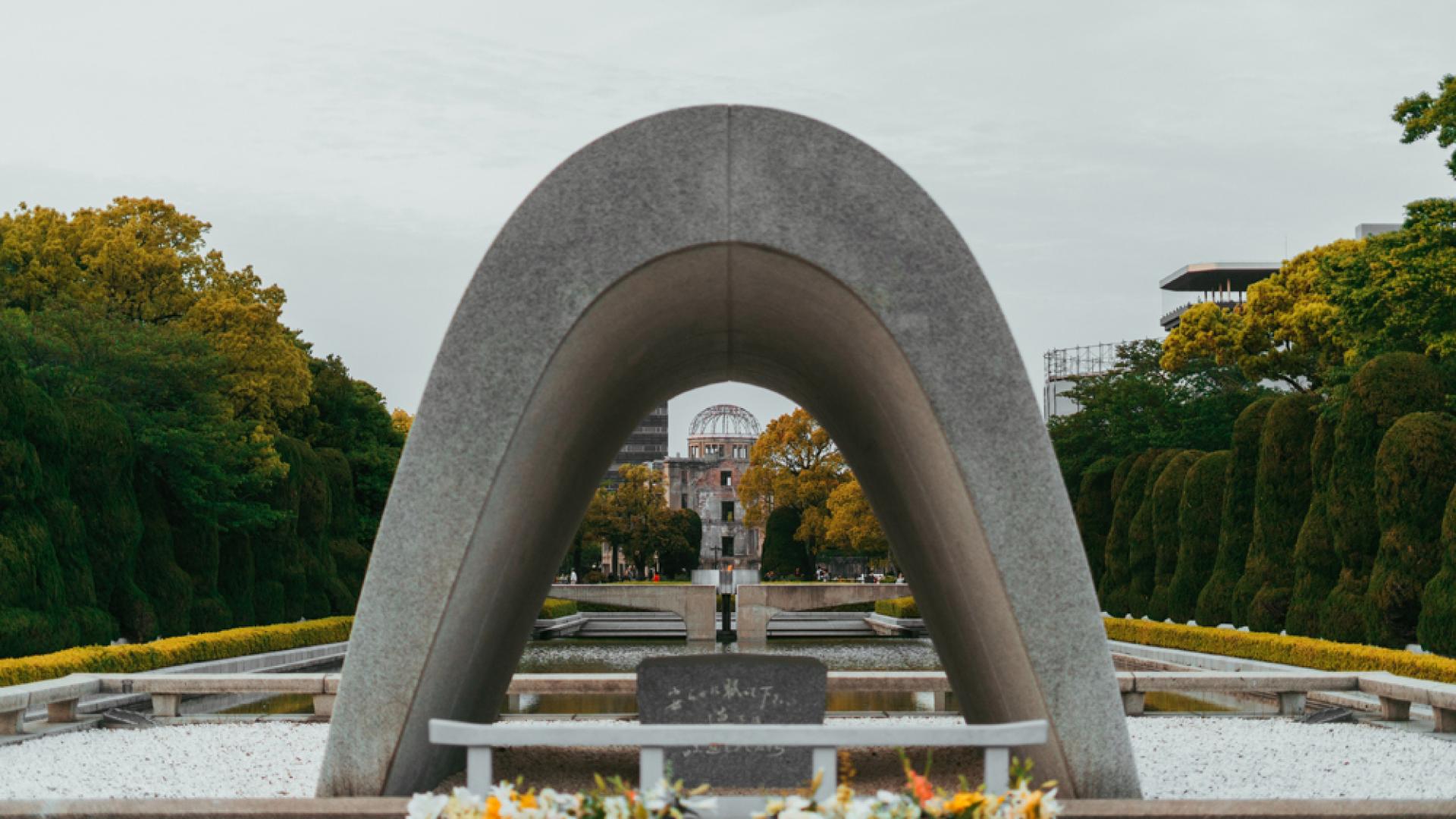 Arco sobre el cenotafio en el Parque Memorial de la Paz en Hiroshima con la Cúpula de la Bomba A a la distancia